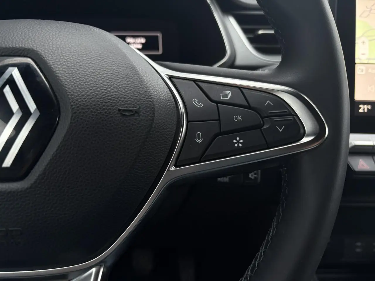 Gros plan sur la partie droite du volant noir du Renault Captur 2025 avec commandes multifonctions et écran tactile en arrière-plan.