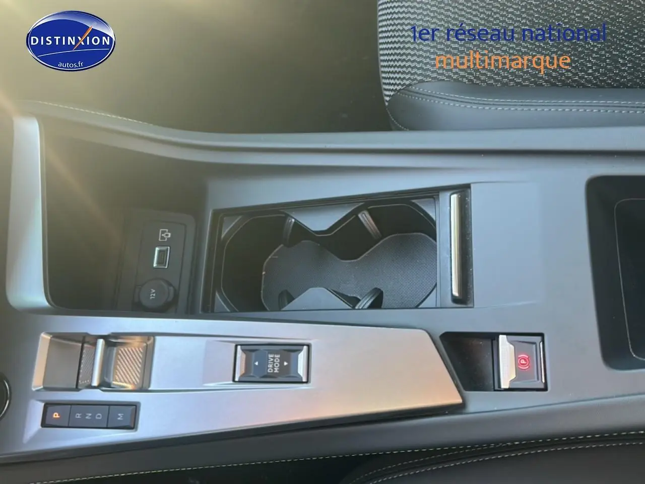 Vue plongeante sur la console centrale grise du Peugeot 408 Hybrid 145 GT avec porte-gobelets et commandes de boîte auto.