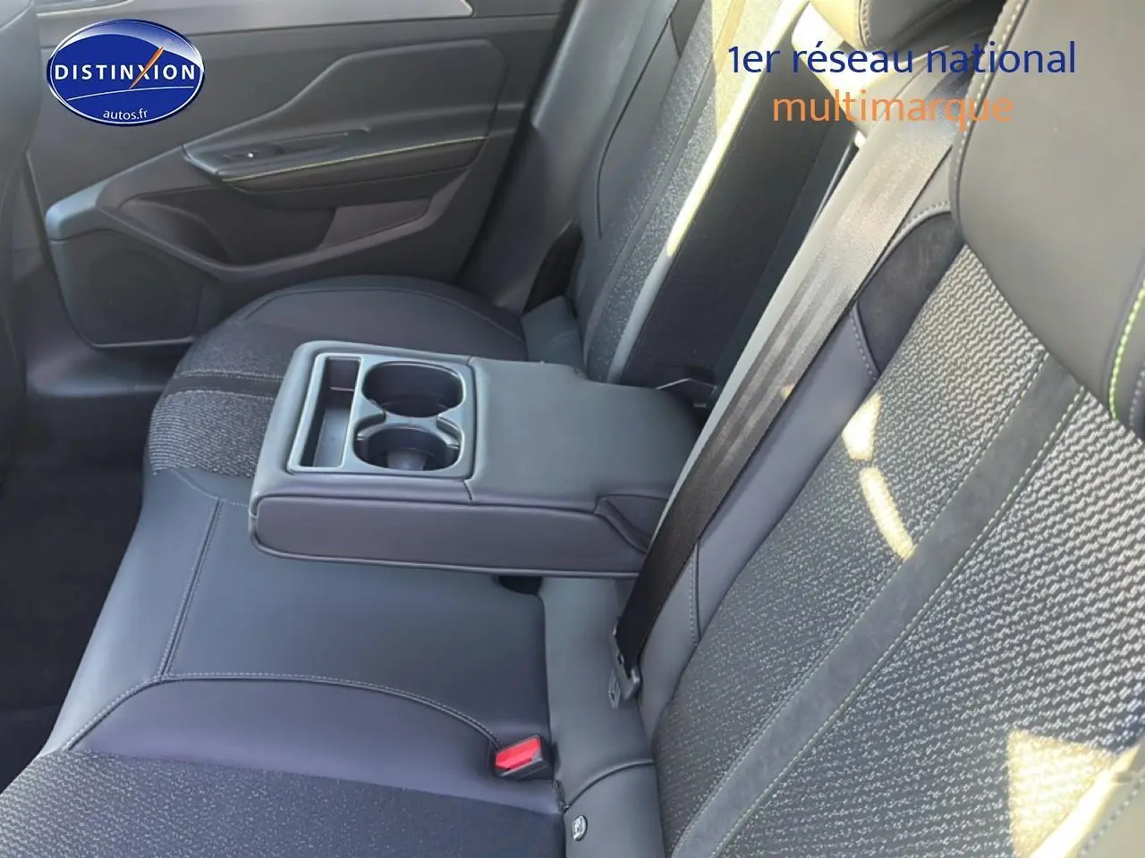 Vue intérieure côté droit de la banquette arrière noire avec accoudoir central et porte-gobelets du Peugeot 408 Hybrid 145 GT.