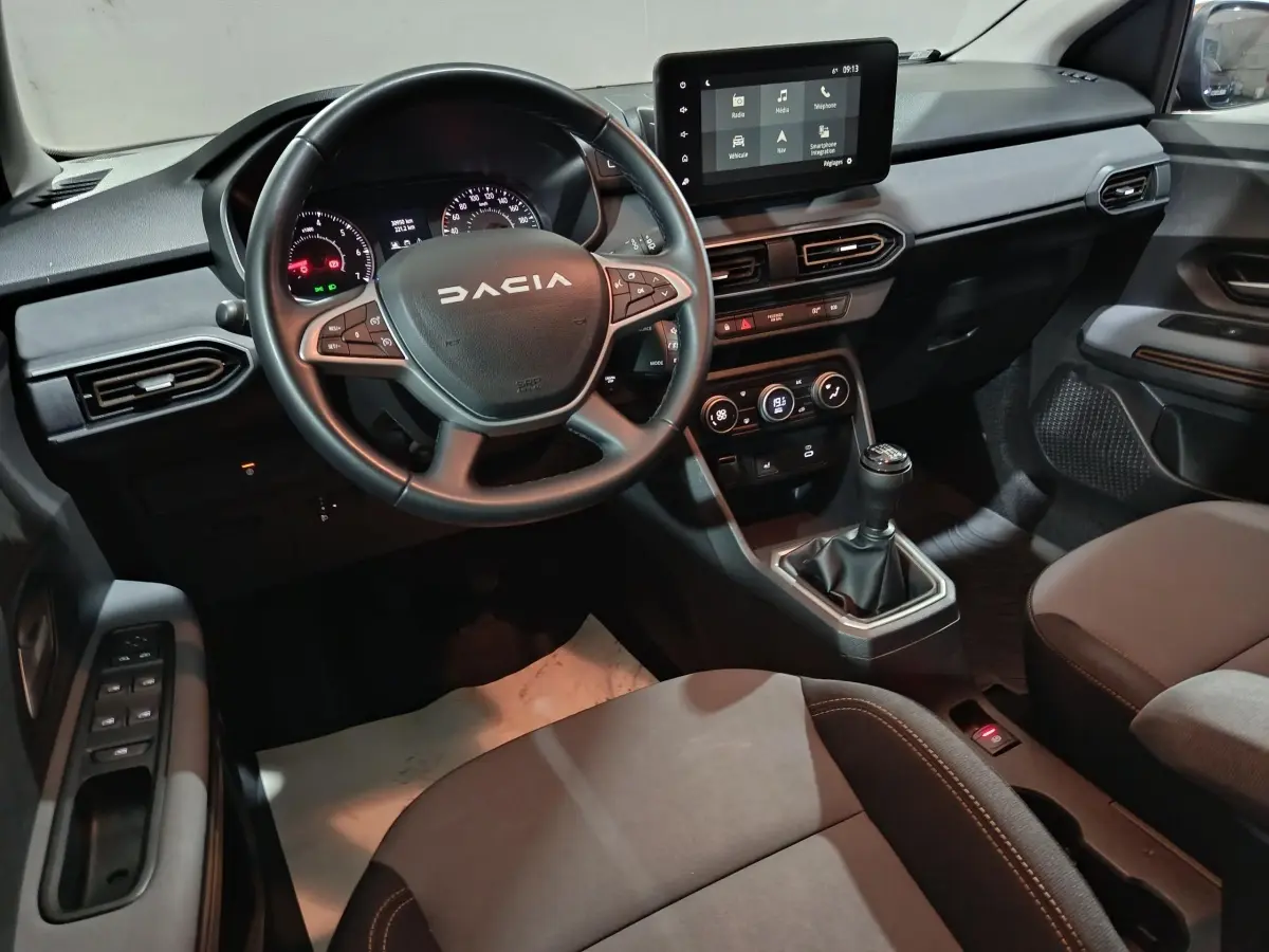 Intérieur de la Dacia Sandero Extreme+ 2024, vue côté conducteur, volant cuir multifonctions et écran tactile central.