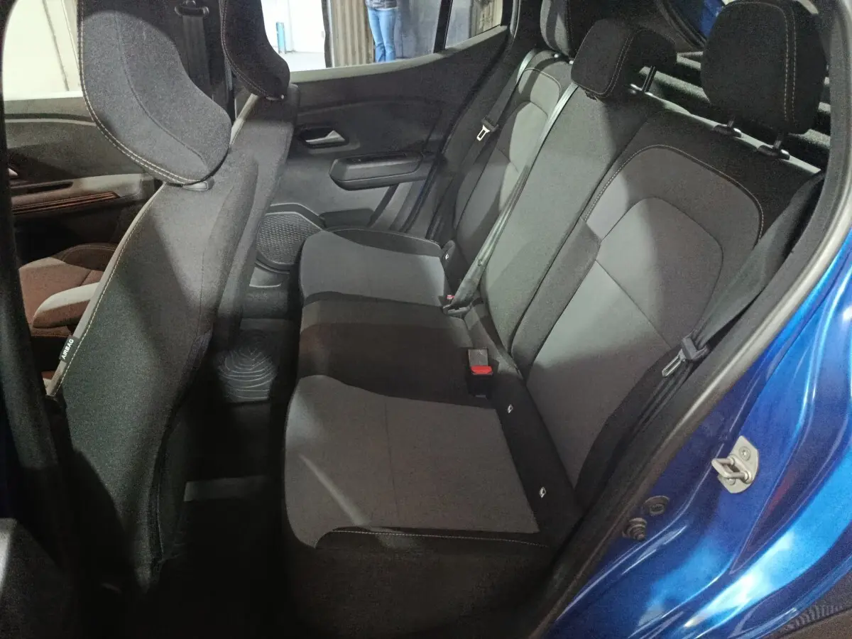 Vue intérieure côté droit sur la banquette arrière grise et noire d'une Dacia Sandero Extreme+ TCe 110 bleu 2024.