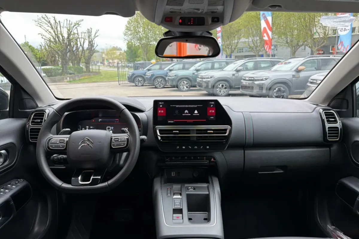 Vue intérieure frontale du tableau de bord du Citroën C5 Aircross Hybrid gris platinium avec écran tactile et volant multifonctions.