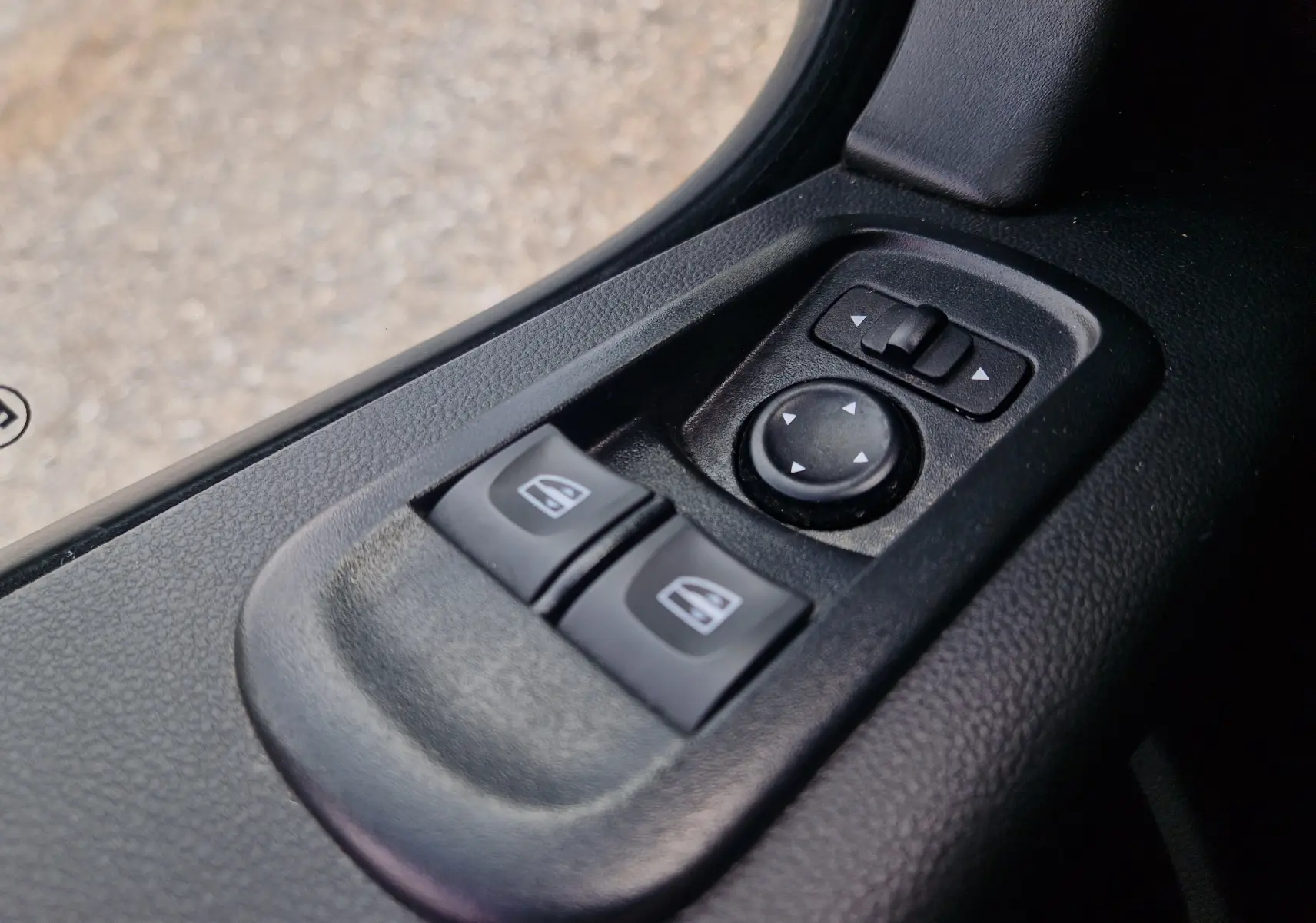 Gros plan sur les commandes de lève-vitres et réglage des rétroviseurs côté conducteur du Renault Master Châssis Cabine blanc.