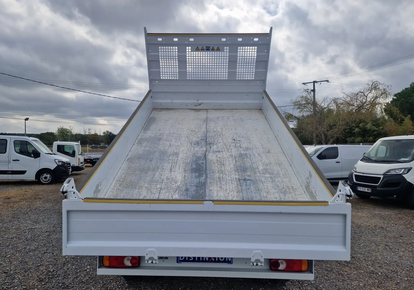 Vue arrière d’une benne blanche relevée sur un Renault Master Châssis Cabine 2024 avec roues jumelées.