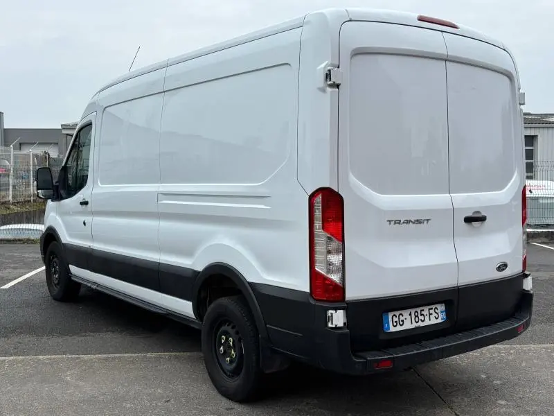 Vue 3/4 arrière droite d'un Ford Transit Fourgon blanc Glacier avec portes battantes et roue de secours visible