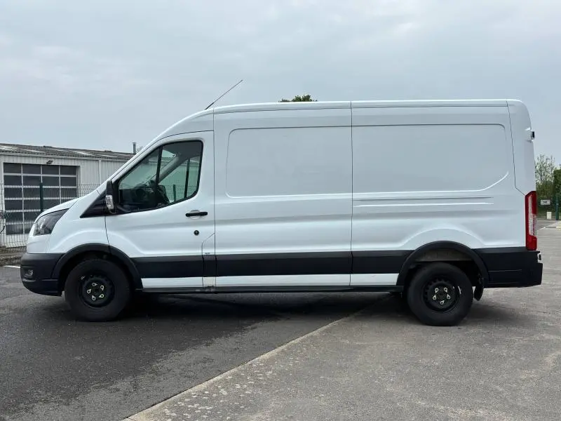 Profil côté gauche d'un fourgon Ford Transit blanc glacier avec porte latérale coulissante et roues noires basiques.