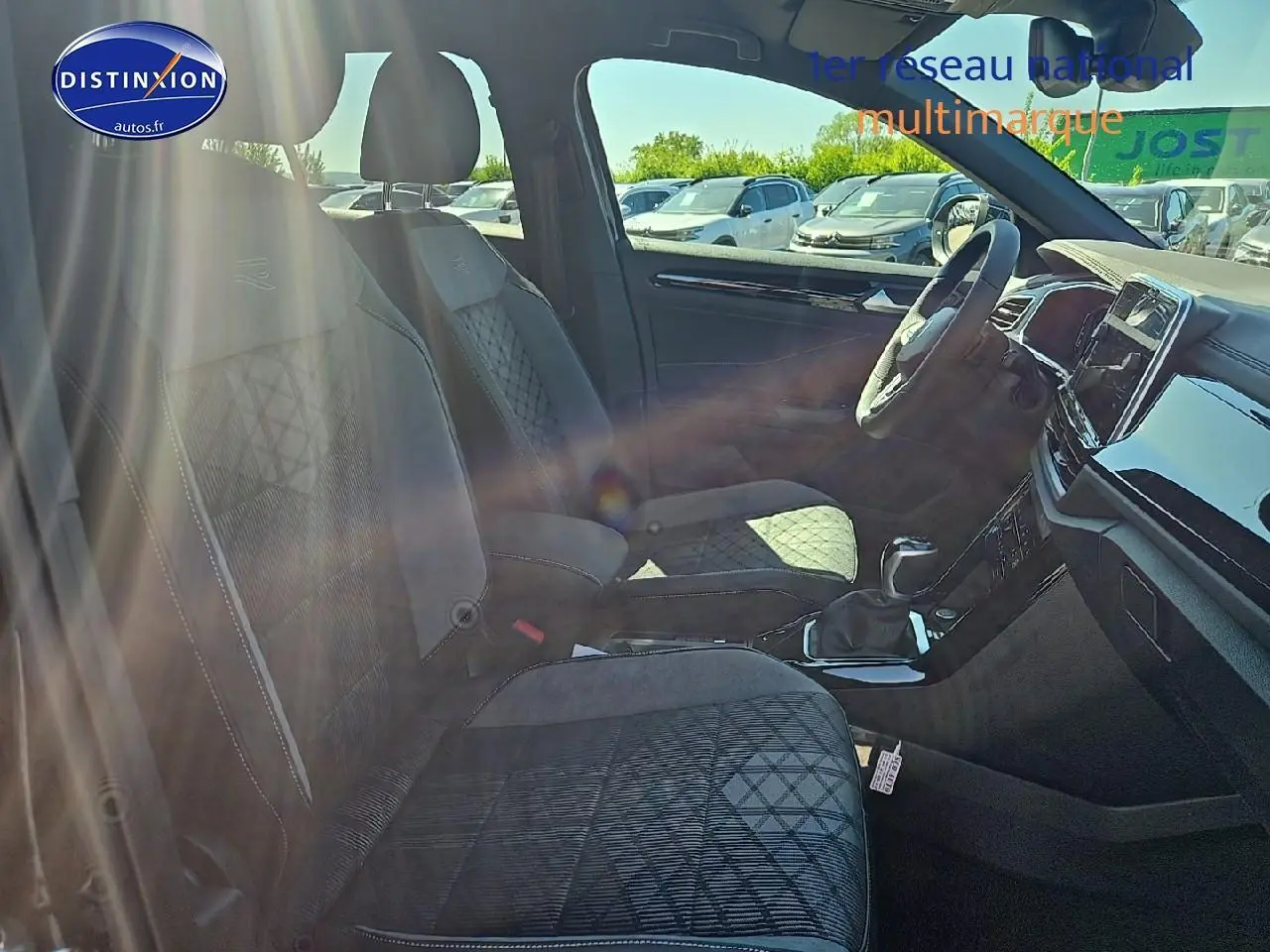 Intérieur du Volkswagen T-Roc 2025 en tissu noir R-Line, vue côté droit sur sièges avant et tableau de bord.