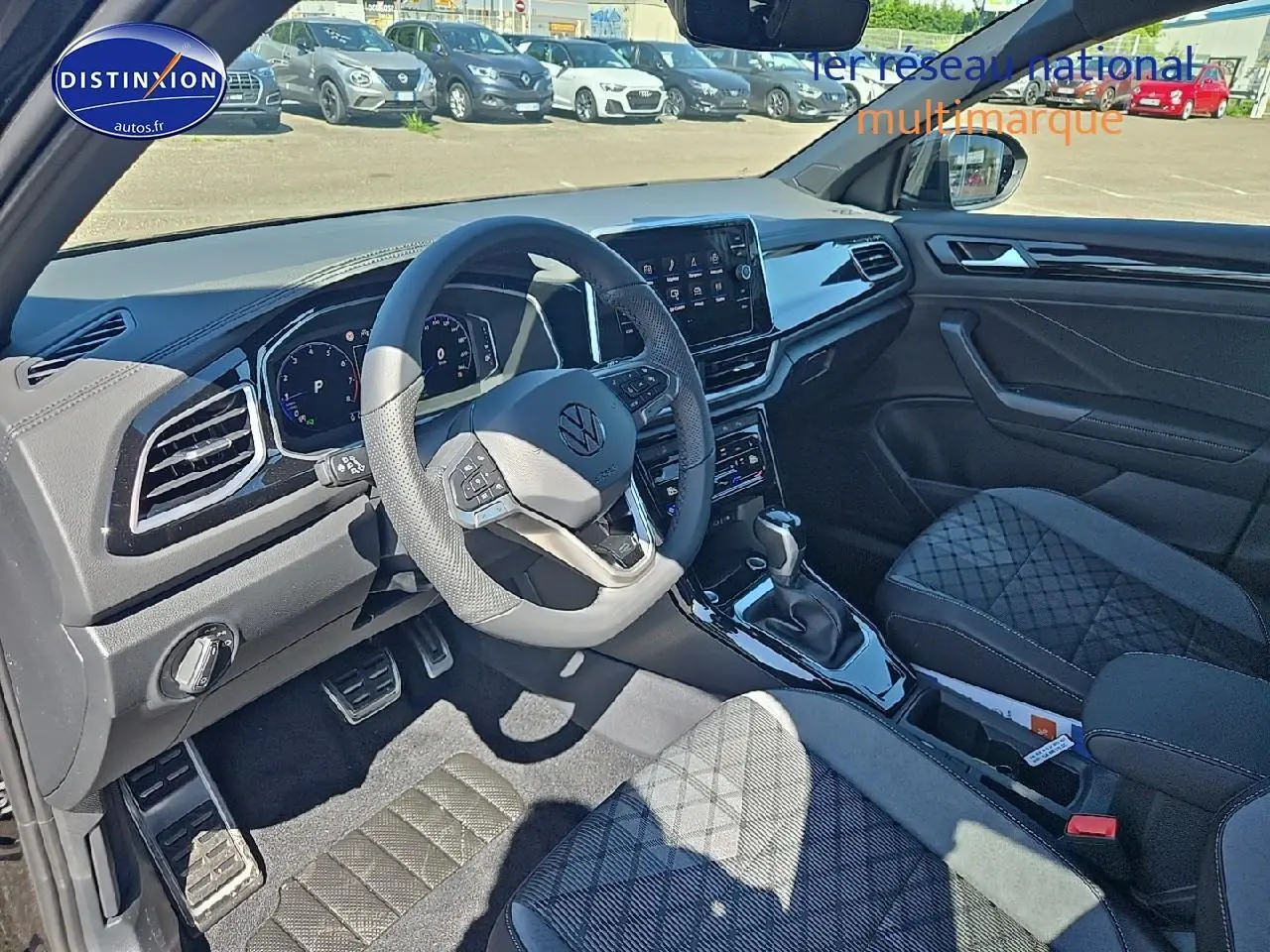 Intérieur noir du Volkswagen T-Roc 2025, vue côté conducteur avec volant cuir multifonction et console centrale moderne.