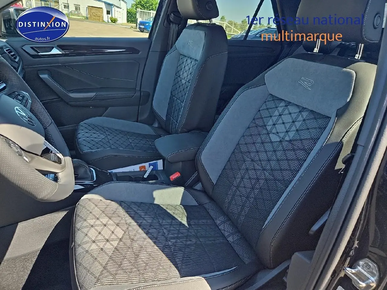 Intérieur Volkswagen T-Roc 2025, vue côté gauche sur sièges tissu noir et gris avec logo R-Line brodé.