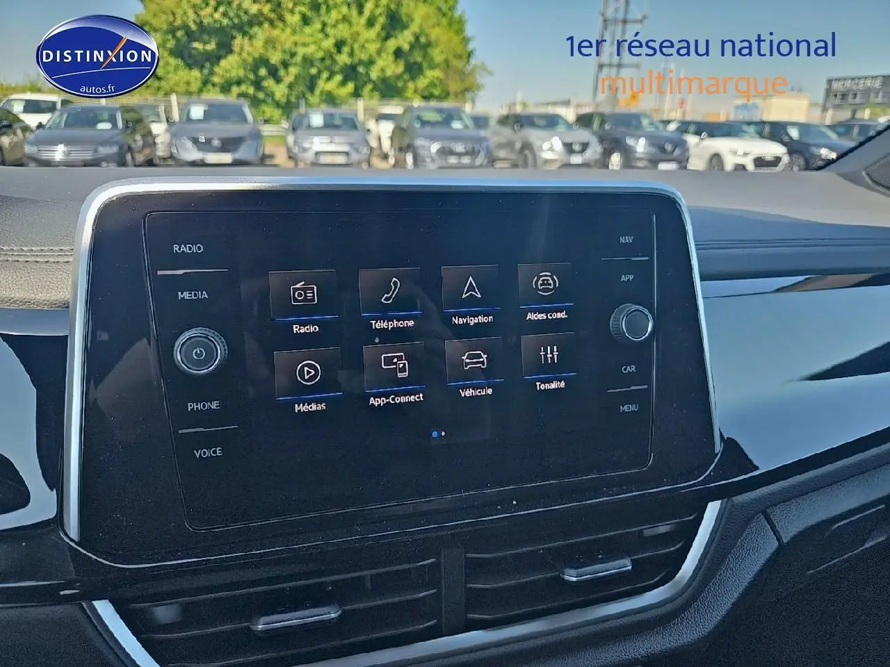 Écran tactile central du tableau de bord du Volkswagen T-Roc noir perle, avec menus radio et navigation visibles.