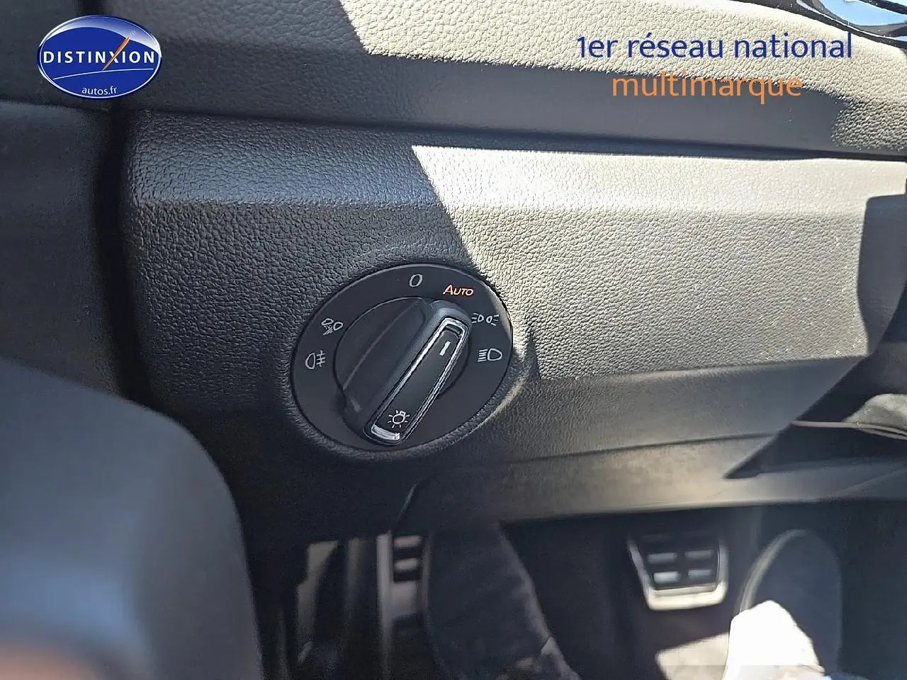 Gros plan sur l'interrupteur des phares du Volkswagen T-Roc noir perle, côté gauche du tableau de bord.