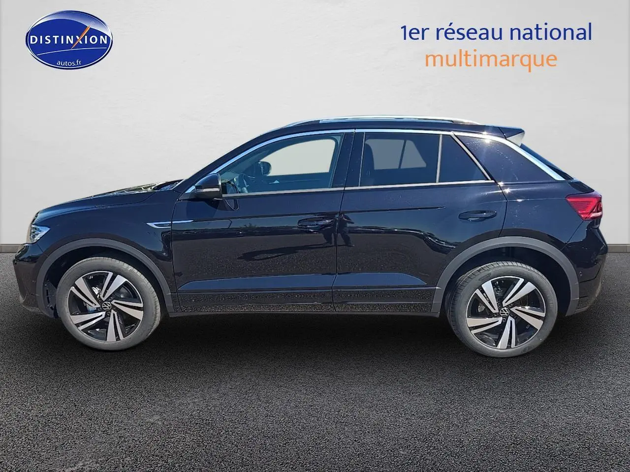 Profil côté gauche d'un Volkswagen T-Roc noir perle 2025 avec jantes alliage et barres de toit argentées.