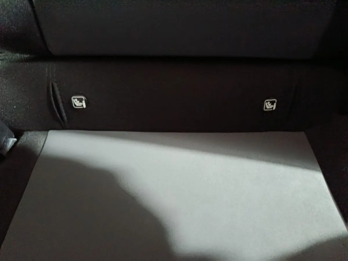 Détail du coffre intérieur noir de la Dacia Sandero Extreme+ TCe 110 avec fixations Isofix visibles sur la banquette arrière.