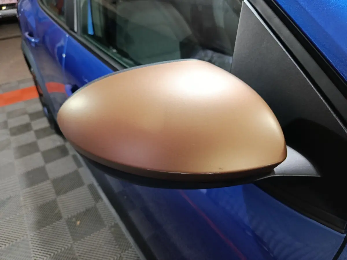 Rétroviseur droit bronze sur Dacia Sandero Extreme+ TCe 110 bleu, vue rapprochée côté conducteur.