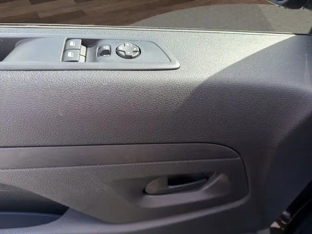 Détail de la porte intérieure côté conducteur du Citroën Jumpy gris foncé avec commandes électriques des vitres et rétroviseurs.