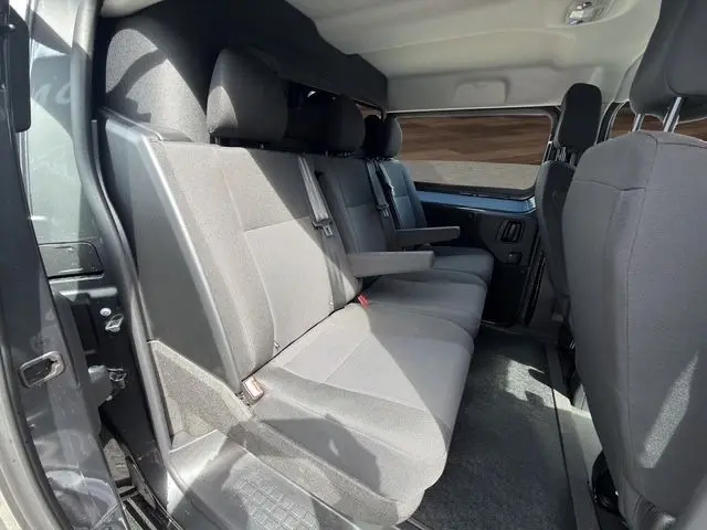 Vue intérieure côté droit montrant la banquette arrière grise du Citroën Jumpy 2026 avec accoudoir central déployé.