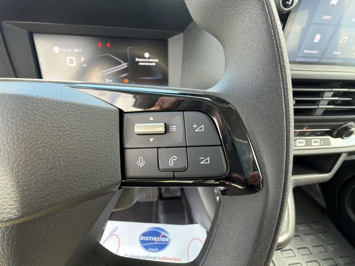 Gros plan sur les commandes du volant multifonctions noir du Citroën Jumpy 2026, intérieur moderne et écran digital en arrière-plan.