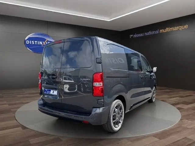 Vue 3/4 arrière droite d'un Citroën Jumpy gris foncé avec vitres teintées et jantes alliage noires.