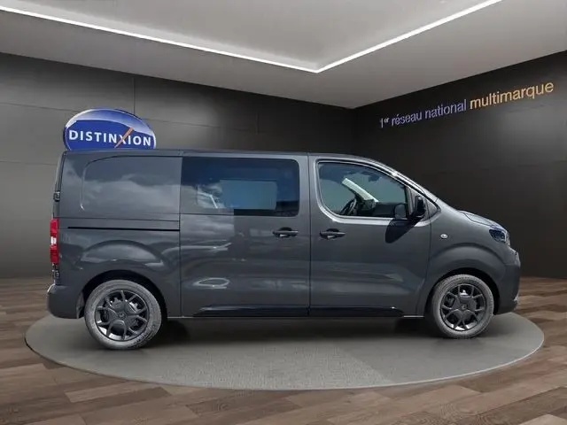 Vue de profil côté droit d’un Citroën Jumpy gris foncé 2026 avec vitres latérales et jantes noires.