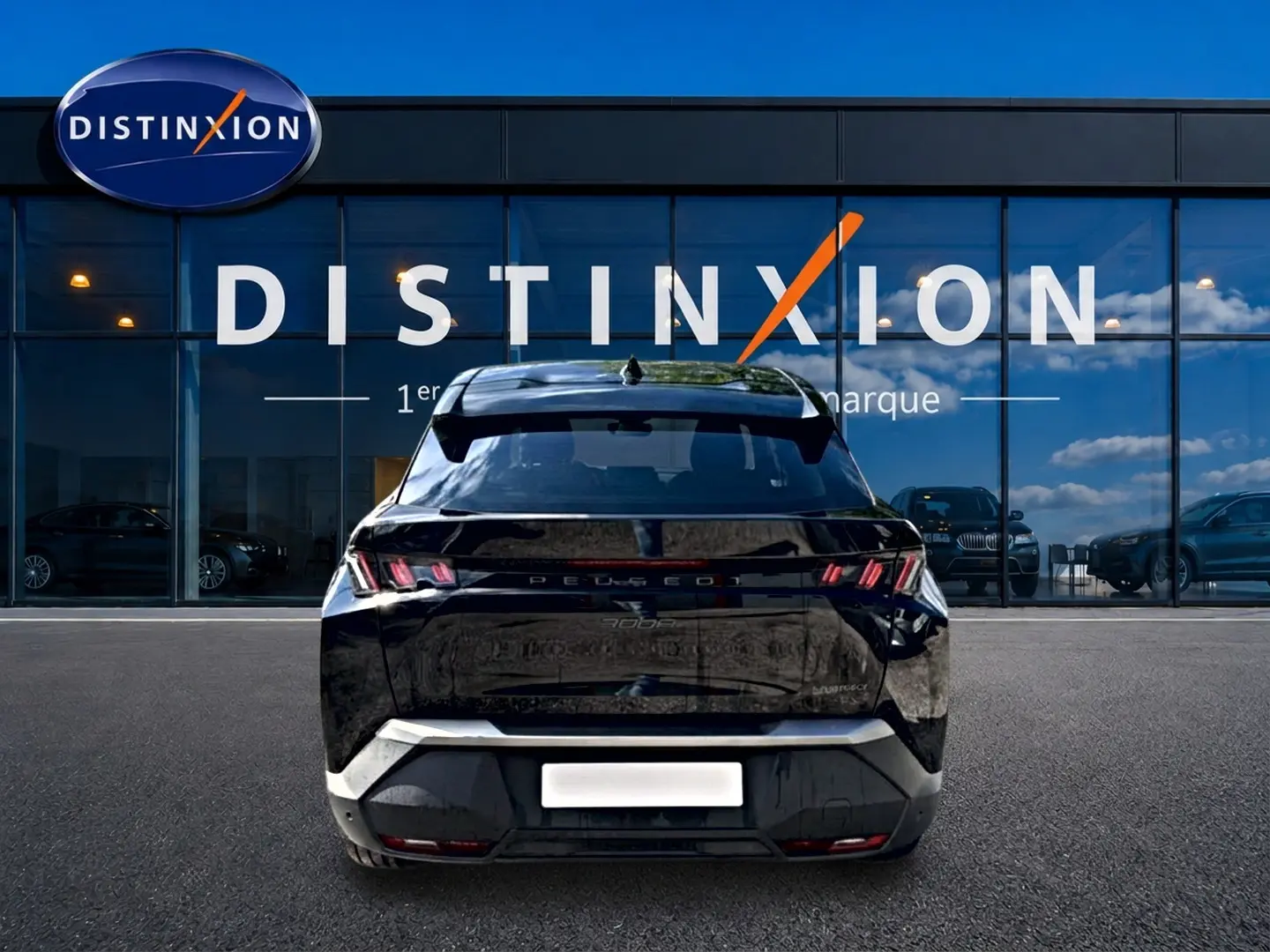 Vue arrière du Peugeot 3008 noir 2025 avec feux LED caractéristiques et becquet arrière, devant une vitrine Distinxion.