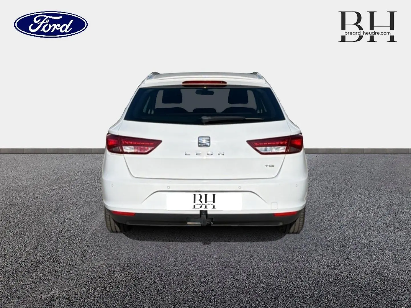 Vue arrière d'une SEAT Leon ST gris étoile, avec feux arrière LED et barres de toit visibles.