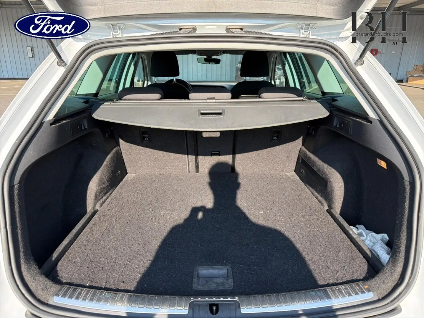 Coffre ouvert d’un SEAT LEON ST gris étoile, vue arrière montrant l’espace de chargement et la tablette cache-bagages.