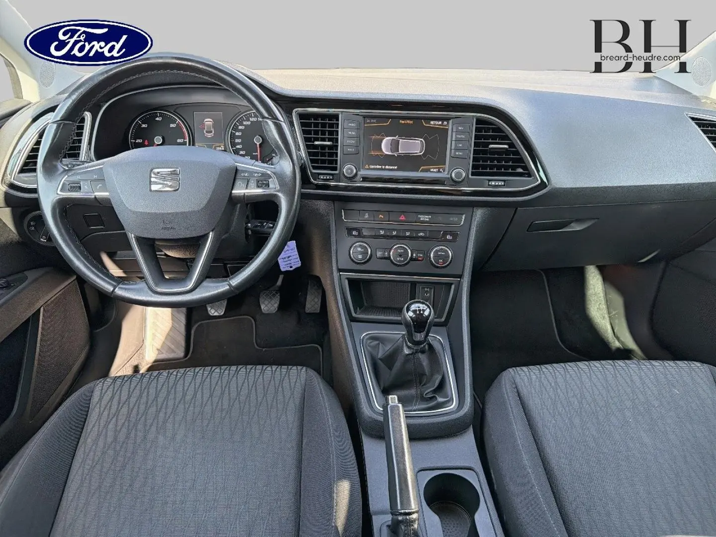 Intérieur avant d'une SEAT LEON ST 2017, vue de face sur tableau de bord noir et volant multifonction cuir.