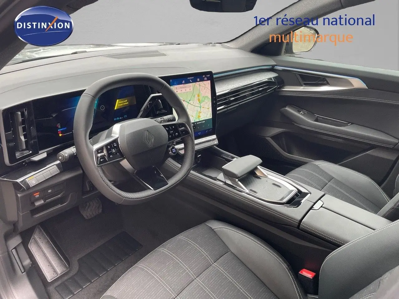 Intérieur avant droit du Renault Austral E-Tech gris, tableau de bord moderne avec écran tactile et volant multifonction.