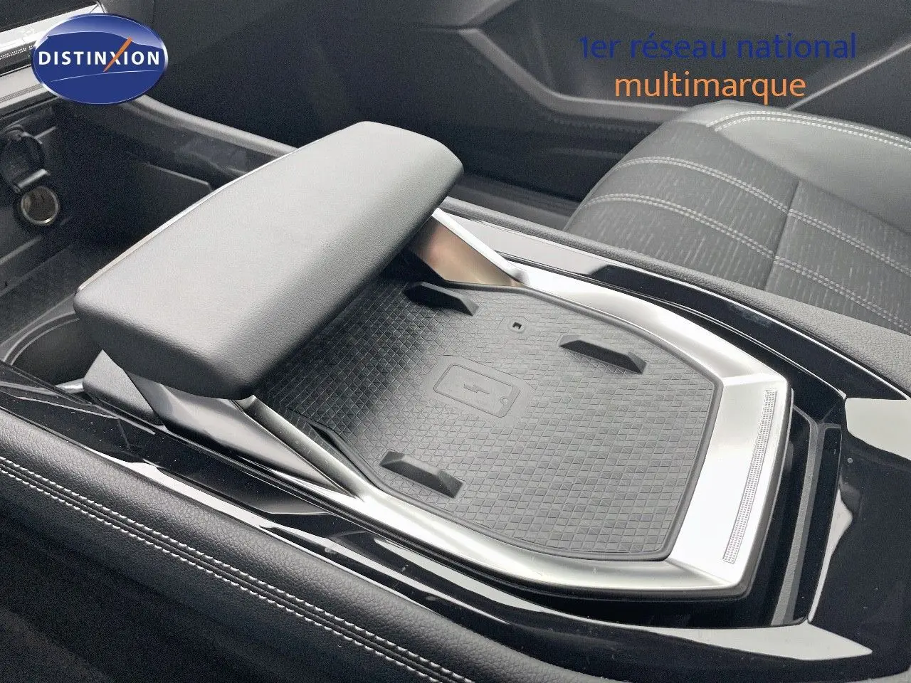 Détail de la console centrale avec accoudoir et surface de recharge sans fil du Renault Austral gris schiste métal 2025.