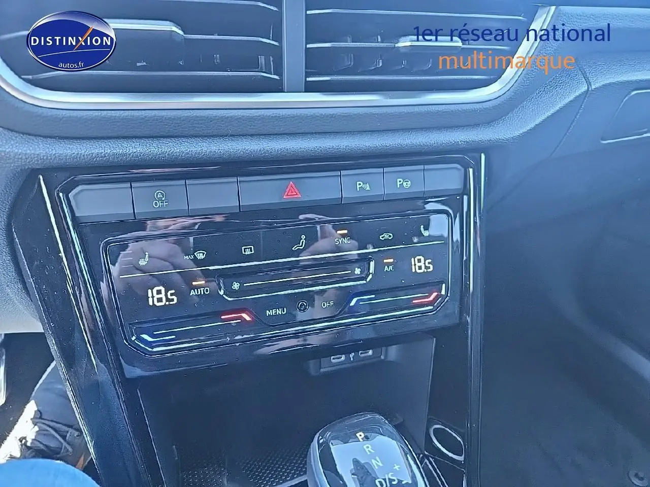 Gros plan sur la console centrale du Volkswagen T-Roc noir perle, mettant en valeur la climatisation bi-zone et la boîte automatique.
