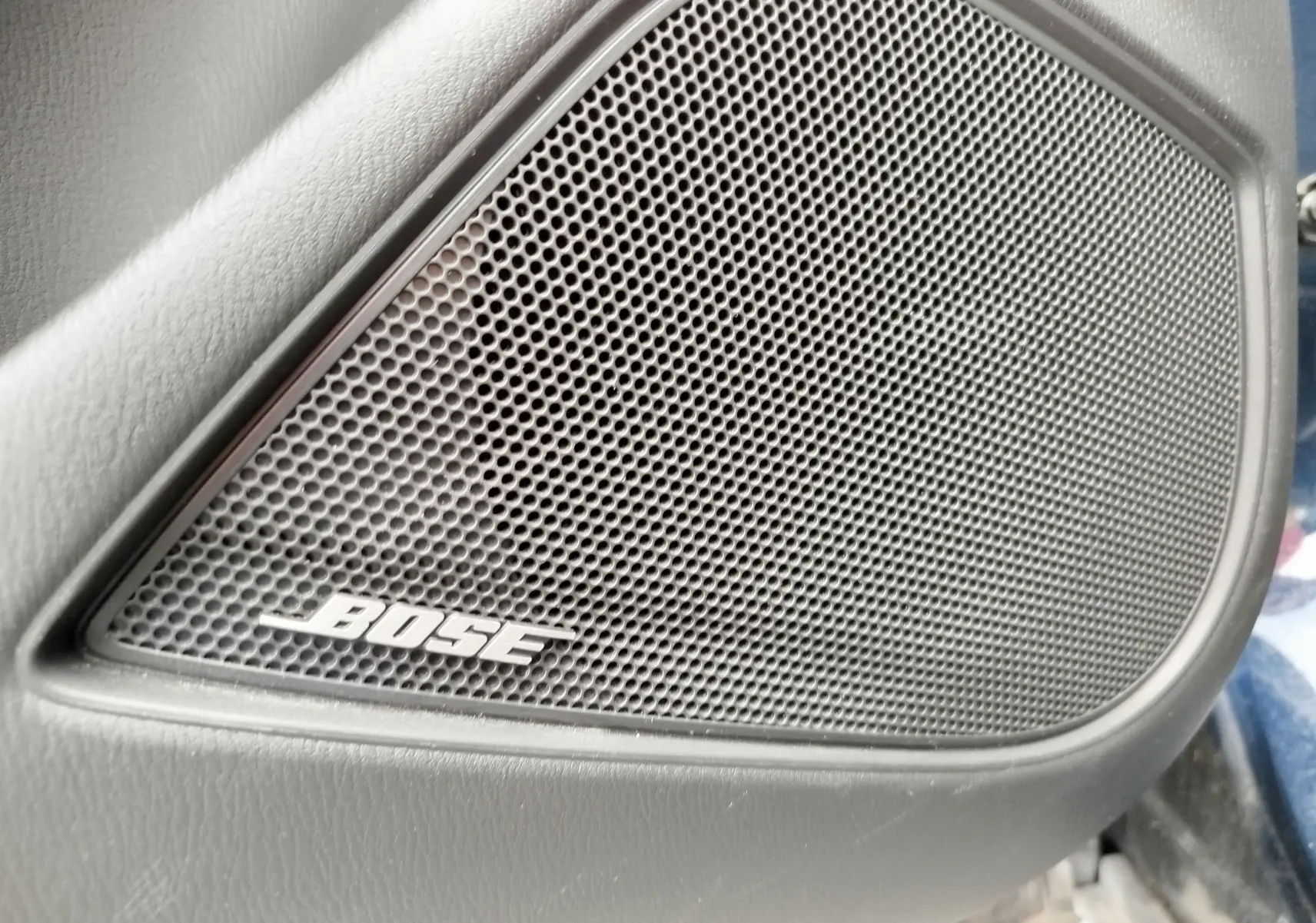 Gros plan sur le haut-parleur Bose intégré à la porte intérieure du Mazda CX-3 bleu Dynamic Blue Mica.