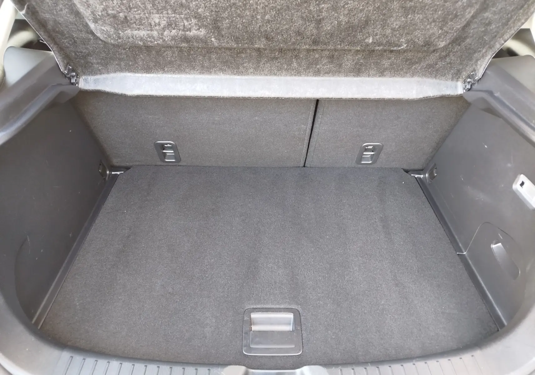 Coffre ouvert de la Mazda CX-3 2016 en bleu Dynamic Blue Mica, montrant un espace de rangement propre et bien fini.