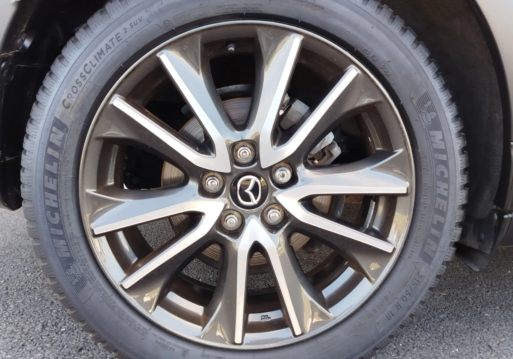 Gros plan sur la jante alliage gris foncé du Mazda CX-3 Dynamic Blue Mica 2016 avec pneu Michelin CrossClimate SUV.