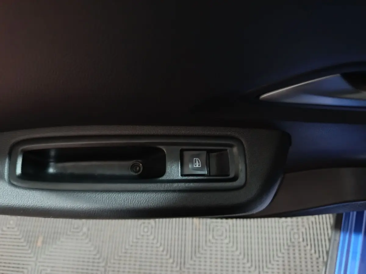 Gros plan sur l'interrupteur de verrouillage des portes dans la portière côté conducteur d'une Dacia Sandero bleu 2024.