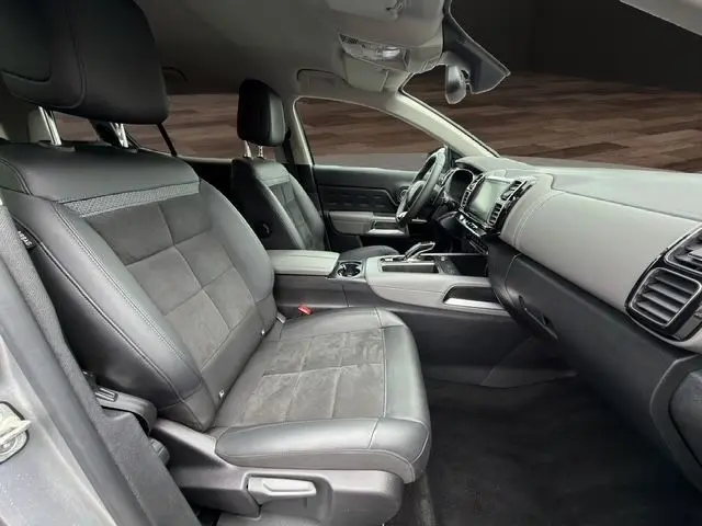 Vue intérieure côté conducteur du Citroën C5 Aircross 2022 gris clair, sièges cuir et tableau de bord moderne avec écran tactile.