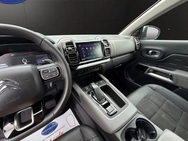 Intérieur du Citroën C5 Aircross 2022 gris clair, vue côté conducteur sur tableau de bord, écran tactile et volant cuir multifonctions.