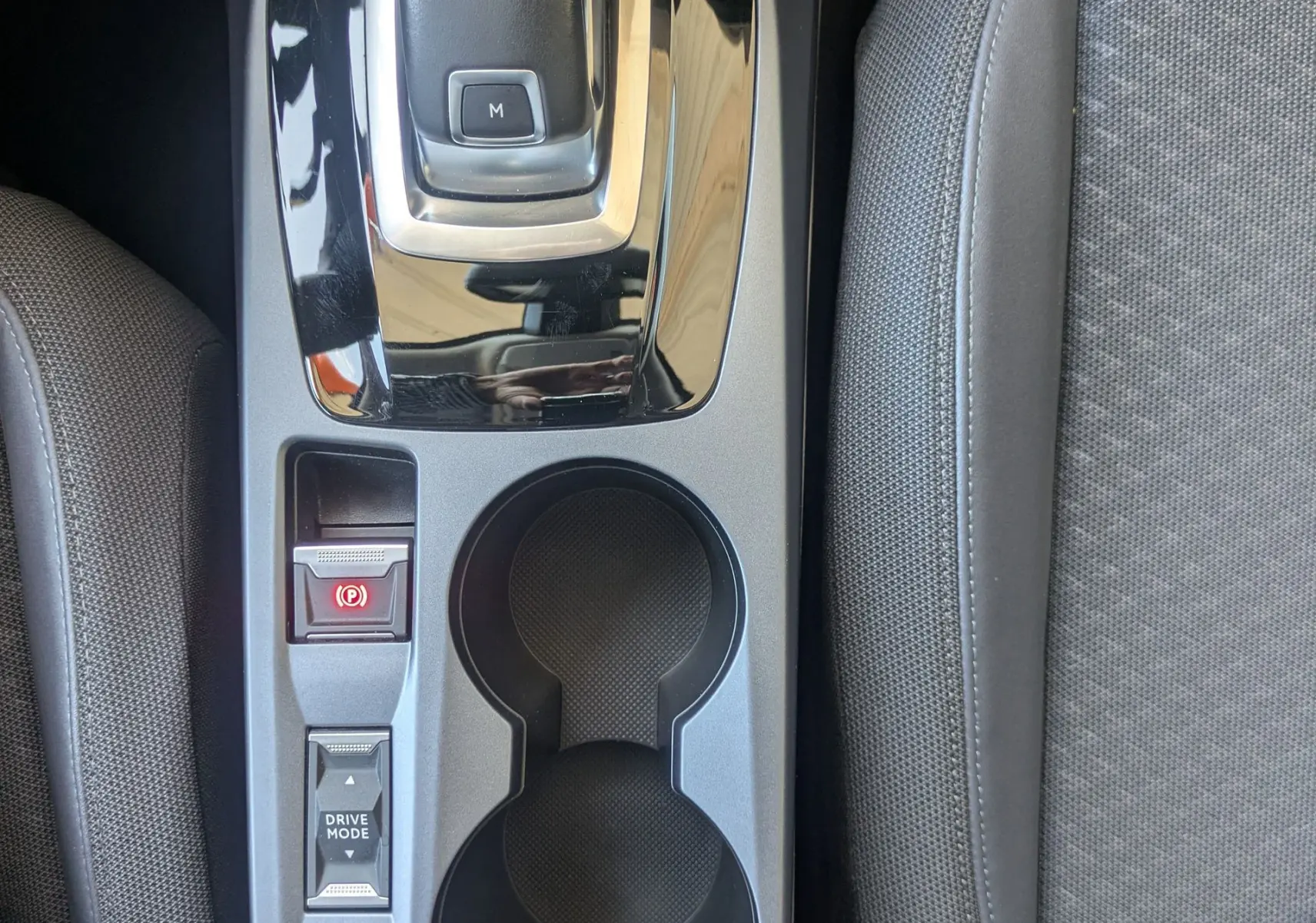 Vue plongeante sur la console centrale grise du Peugeot 2008 avec levier de vitesse automatique et porte-gobelets.