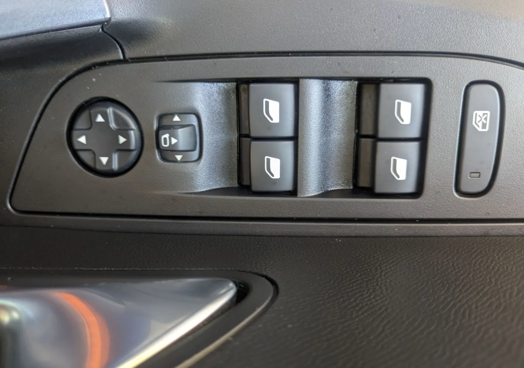 Gros plan sur les commandes de lève-vitres et réglages des rétroviseurs côté conducteur d’un Peugeot 2008 orange.