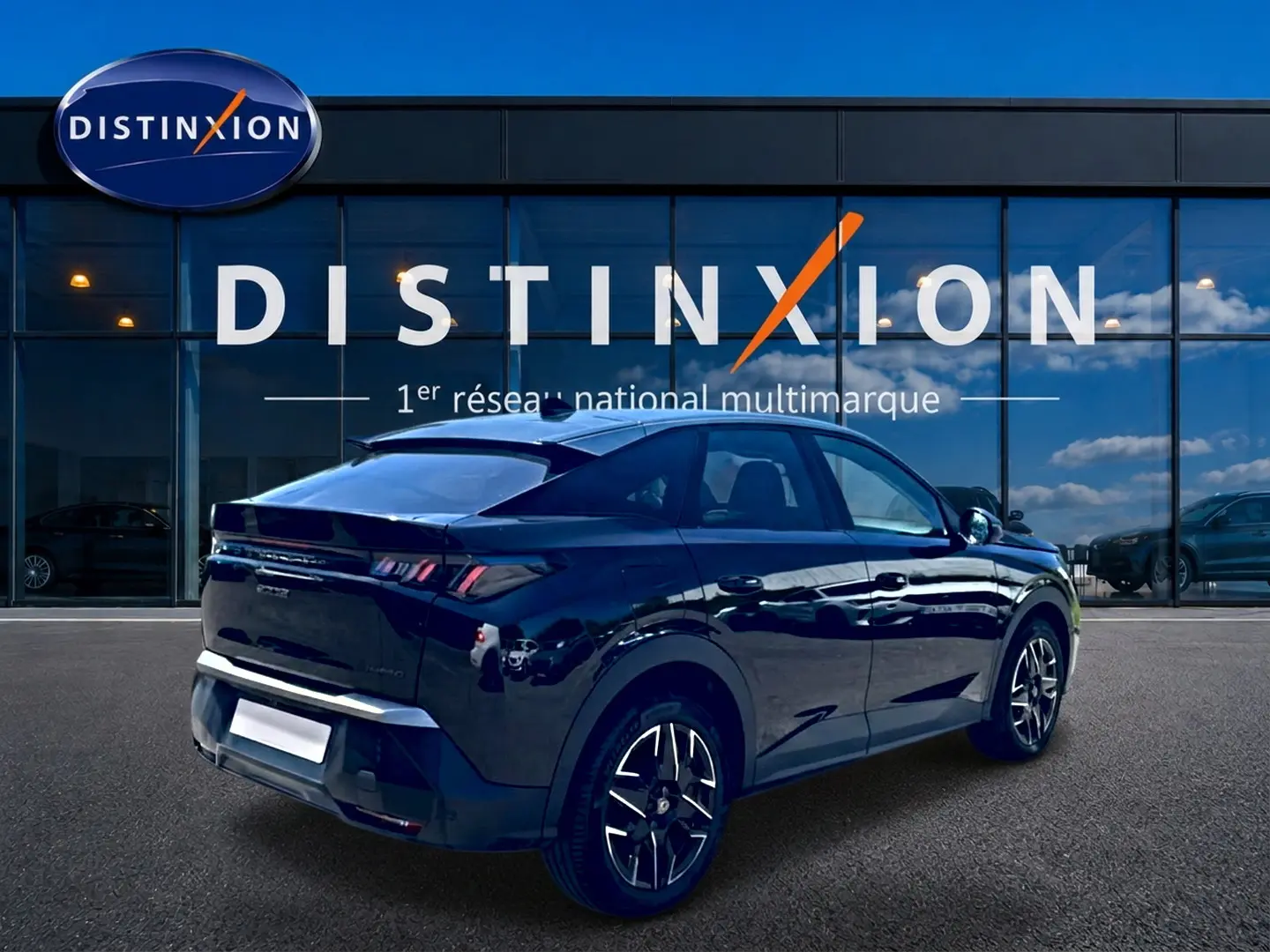 Peugeot 3008 noir en 3/4 arrière droit, avec jantes alu et becquet arrière, devant une vitrine Distinxion.