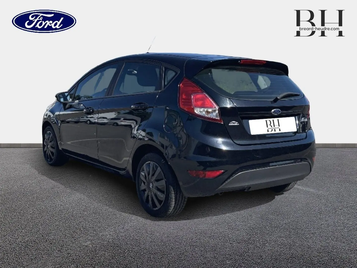 Vue 3/4 arrière droite d'une Ford Fiesta noire Scala avec becquet arrière et feux arrière distinctifs.