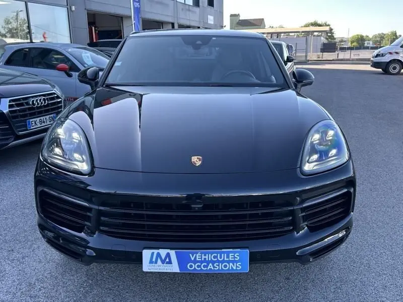 Vue avant d'un Porsche Cayenne coupe 3.0 V6 noir métal de 2020 avec phares LED et calandre imposante.