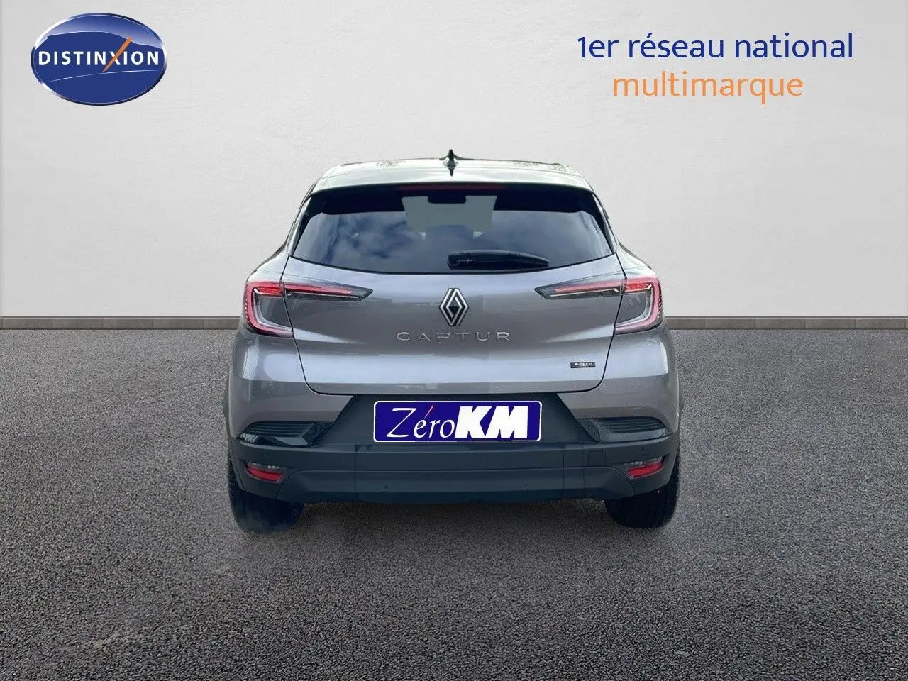 Vue arrière du Renault Captur E-Tech hybride gris Cassiopée métal avec toit noir, feux LED et logo central bien visible.
