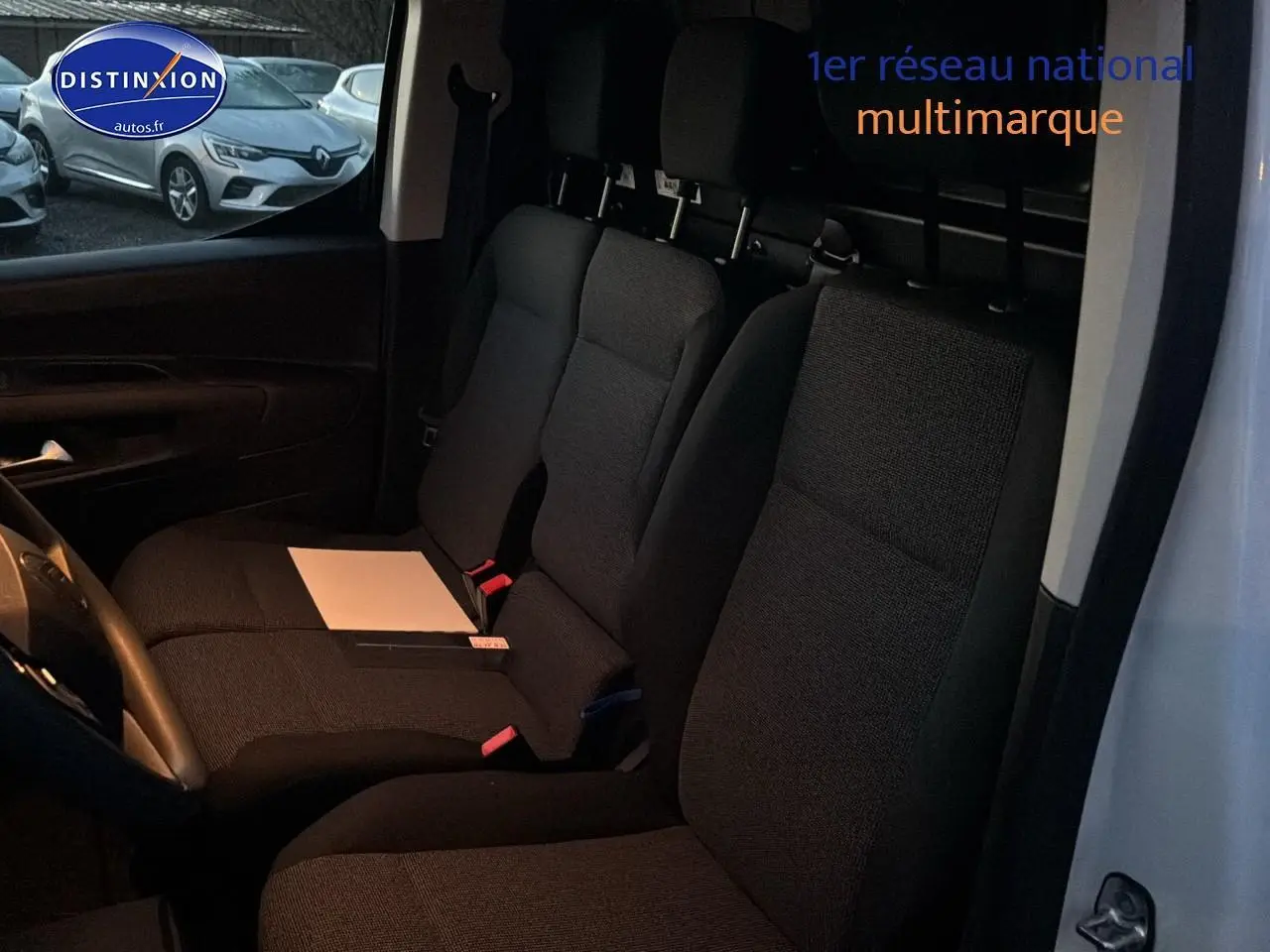 Vue intérieure côté conducteur du Citroën Berlingo Fourgon blanc, montrant les sièges avant et la cloison de séparation.