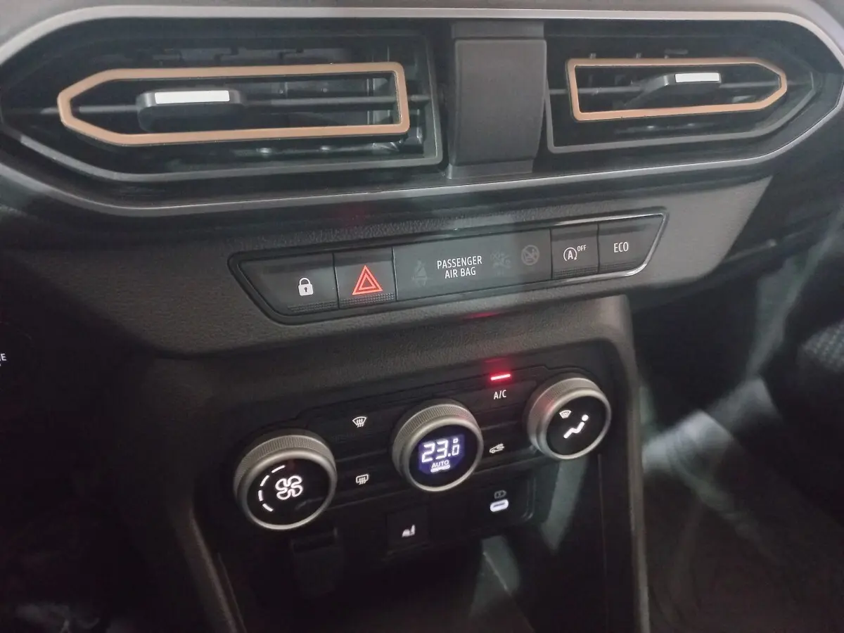Détail de la console centrale noire de la Dacia Sandero Extreme+ 2024 avec commandes climatisation et boutons fonctionnels.