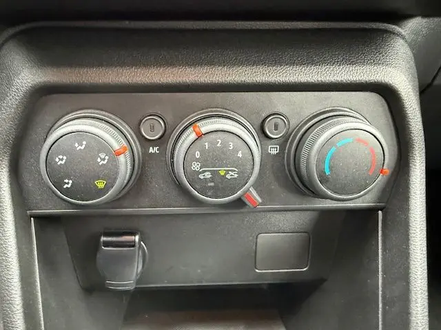 Vue rapprochée des commandes de climatisation manuelle du Dacia Sandero 2023, avec réglages de température, ventilation et air conditionné.