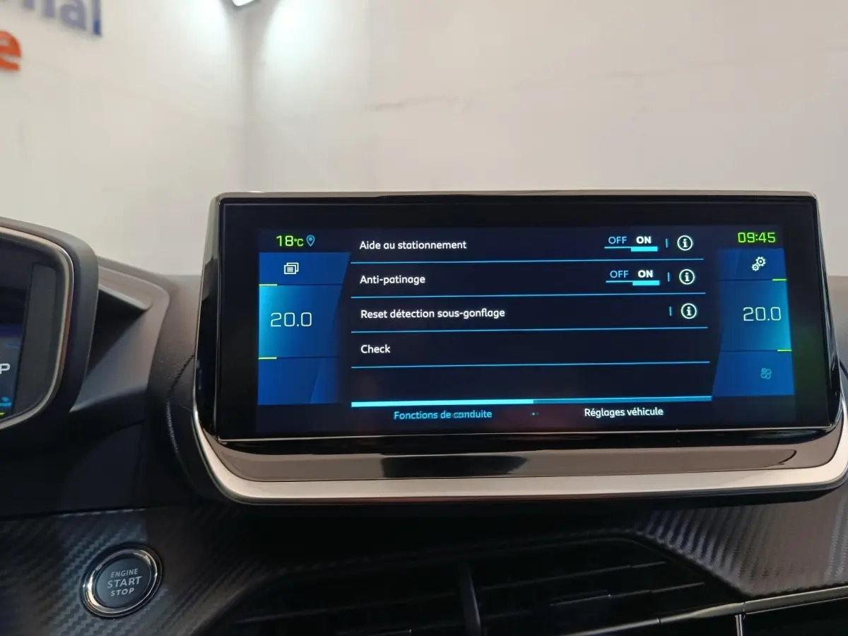 Écran tactile central affichant les réglages d’aide à la conduite dans une Peugeot 208 Electrique gris clair, vue intérieure frontale.