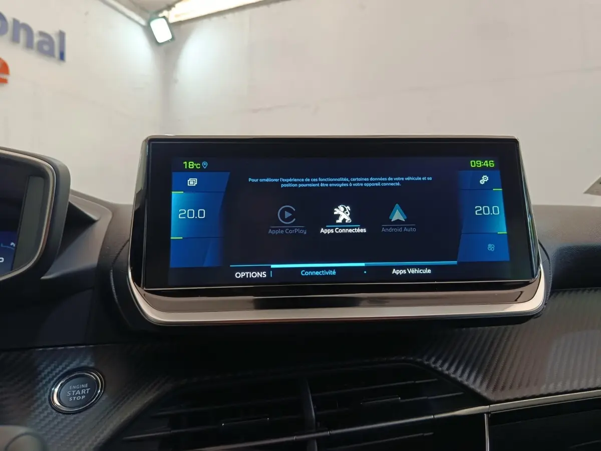 Écran tactile central de 10 pouces affichant Apple CarPlay et Android Auto dans le tableau de bord d’une Peugeot 208 Electrique gris clair.