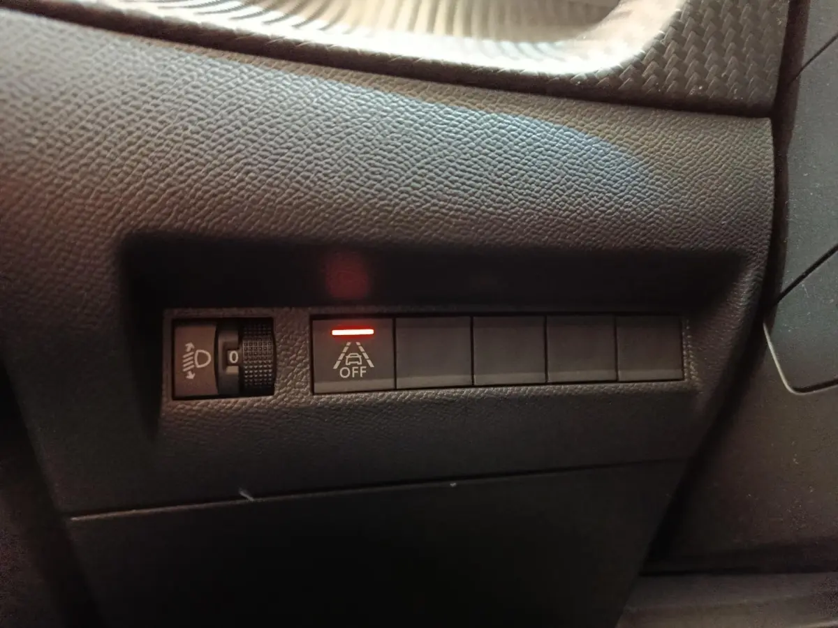 Détail intérieur du tableau de bord côté gauche avec commande d’éclairage et bouton d’alerte franchissement de ligne activé.