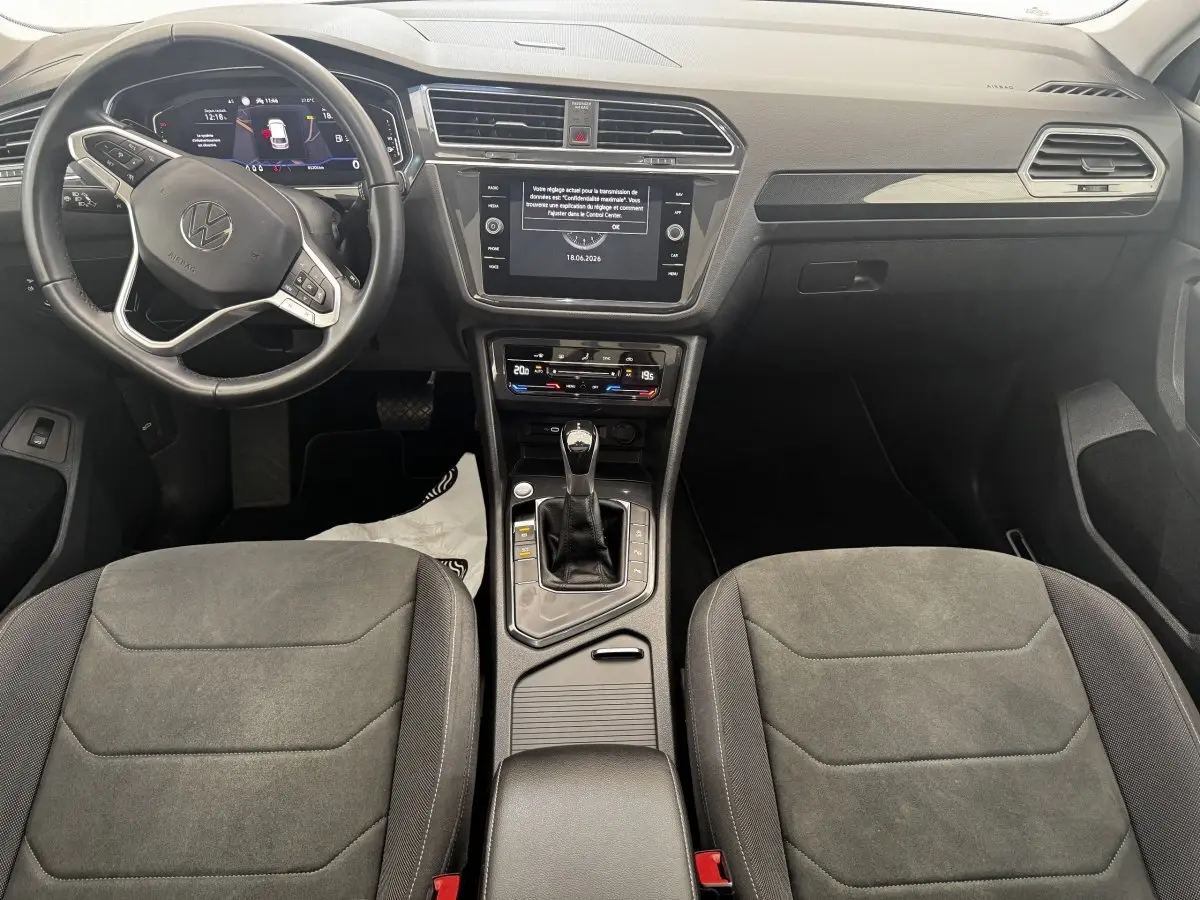 Vue intérieure frontale du Volkswagen Tiguan 1.5 TSI 150 DSG7 Elegance 2021, sièges tissu gris et tableau de bord digital.