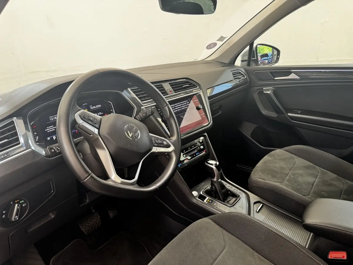 Intérieur Volkswagen Tiguan 1.5 TSI 2021 vu côté conducteur, volant cuir, écran tactile central et sièges tissu gris.